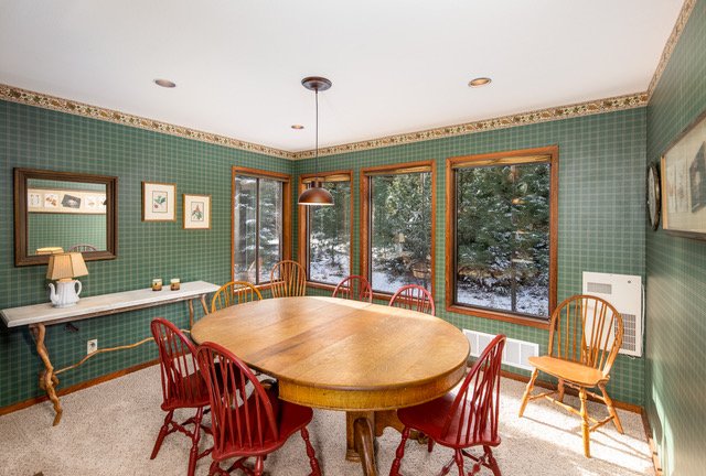 Formal dining room with oval table and forest views