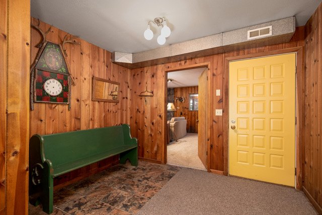 Entry hall with antique pew and cedar paneling