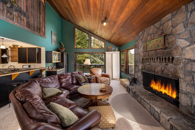 Vaulted cedar great room with stone fireplace and leather seating