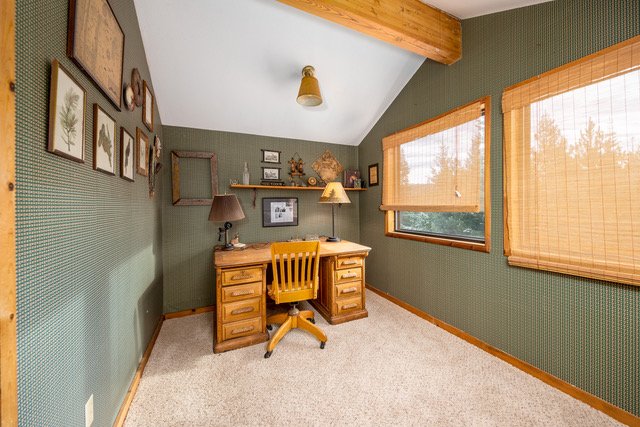 Vaulted study with beamed ceiling and forest window